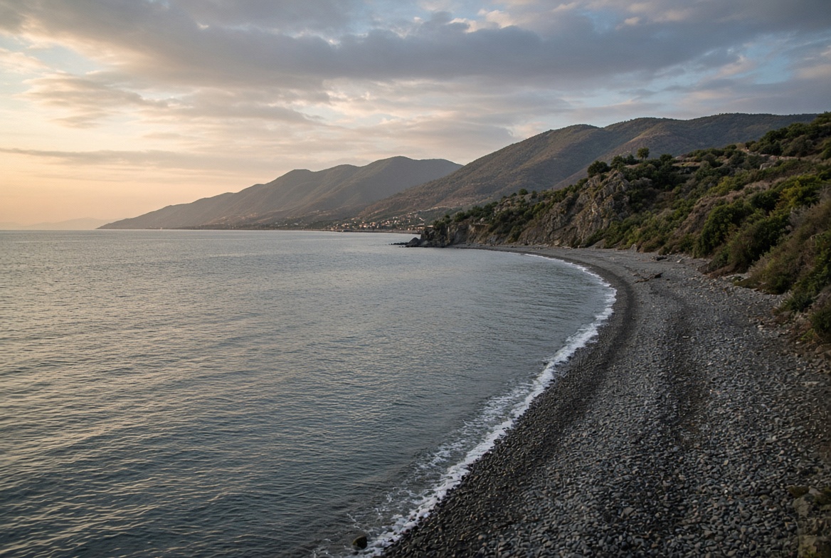 Изогнутый галечный берег и горы у моря